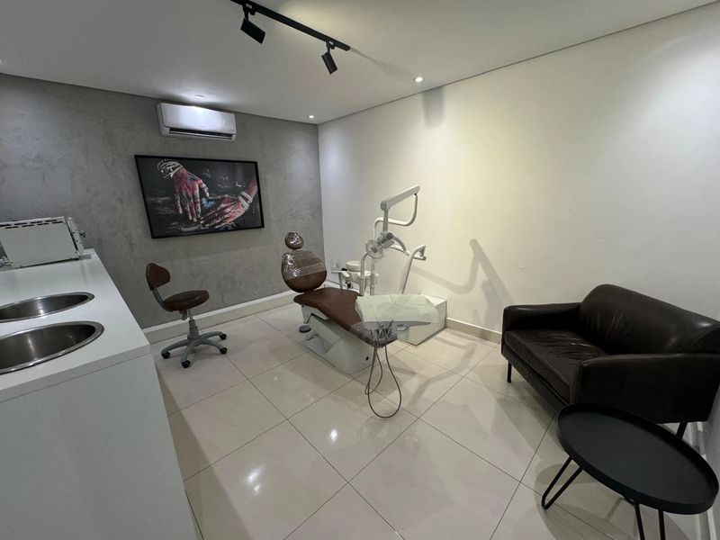 Consultório principal com cadeira odontológica e arte na parede